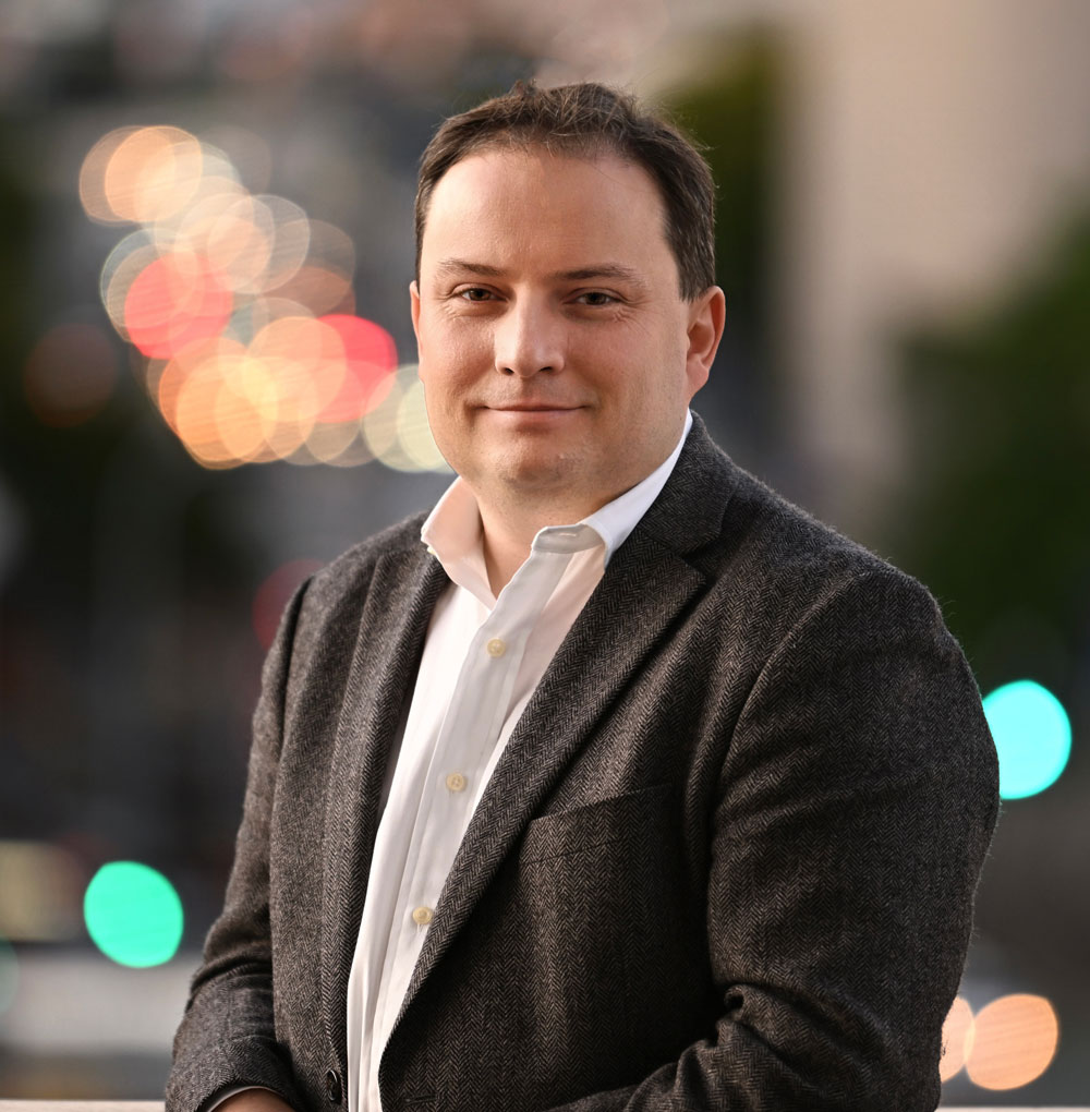 Headshot of Prof Paul Gauthier with city lights behind