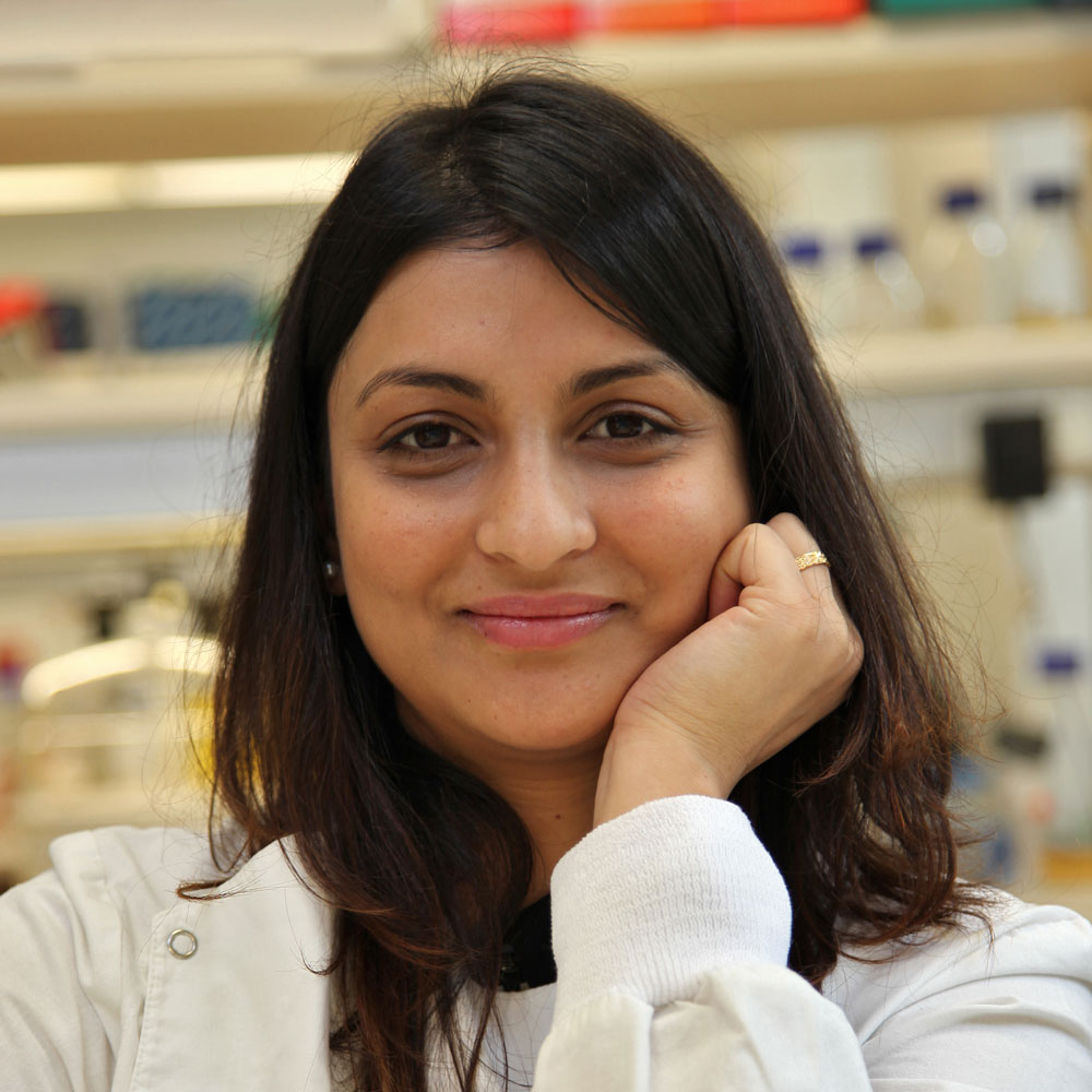 Headshot of Dr Karishma Mody in a lab, resting her chin on her hand