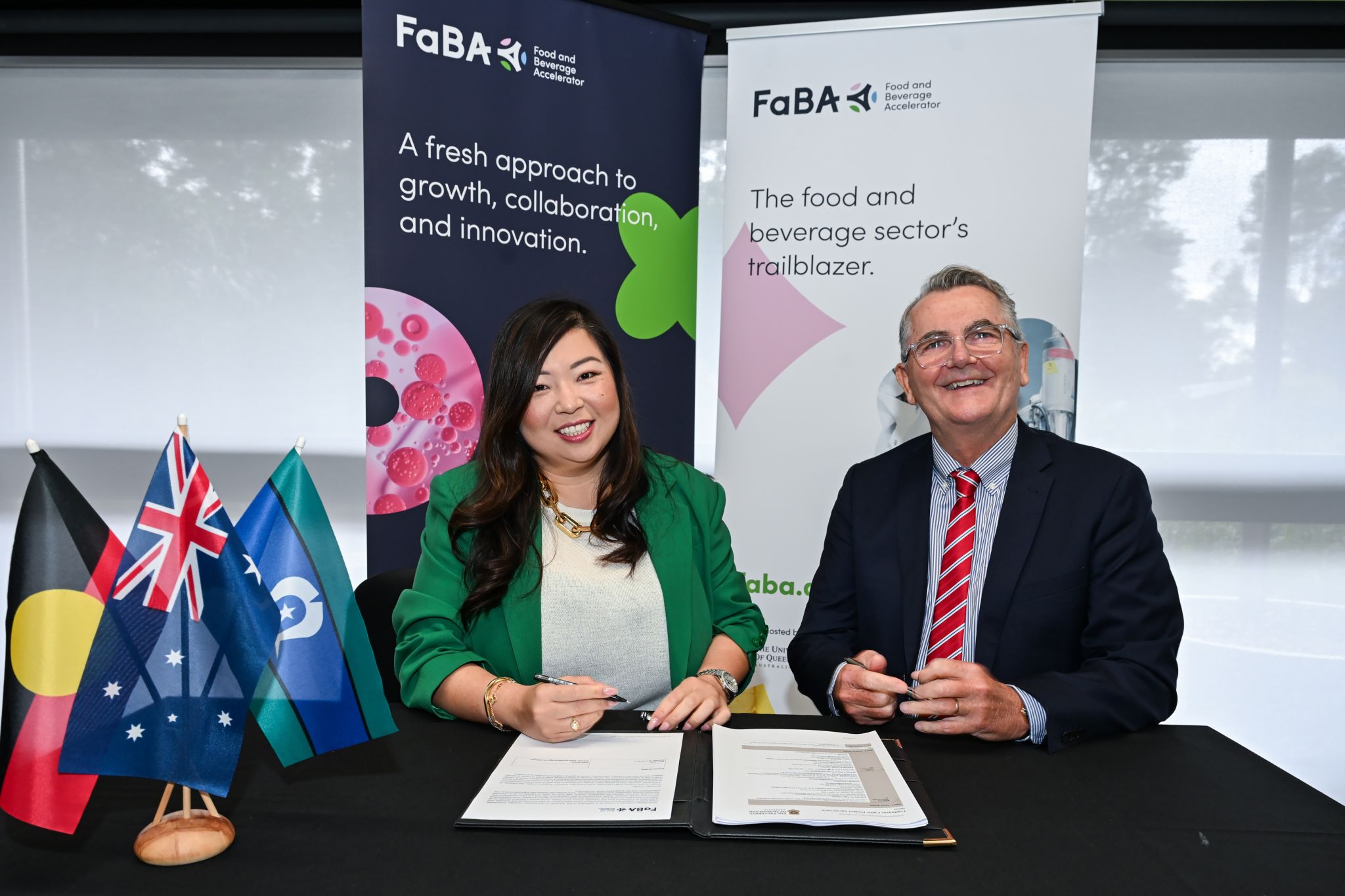 Man and woman seated at desk after signing project agreement