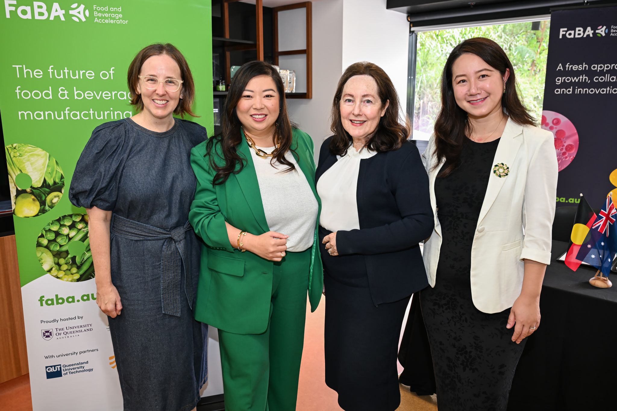 Four women standing in a group smiling at the camera, three researchers and a company founder