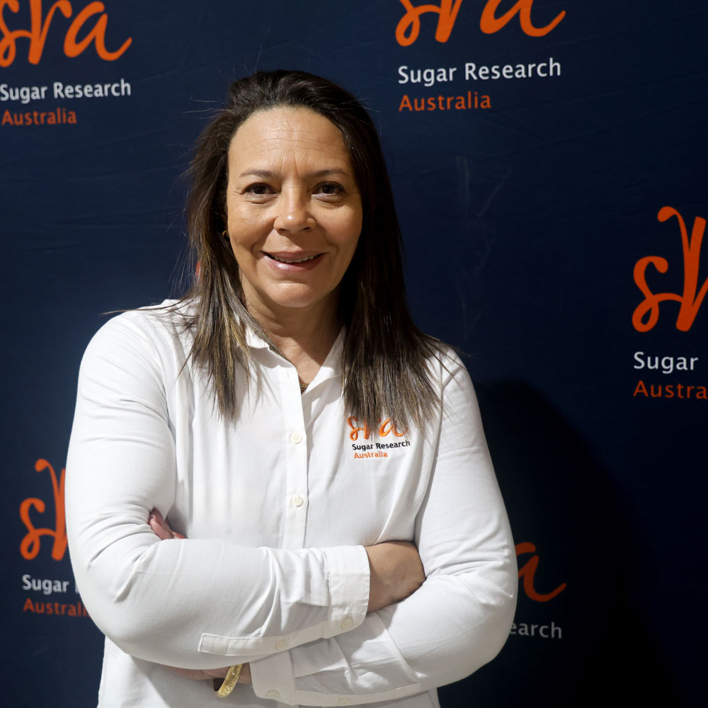 Headshot of Dr Nathalie Piperidis with SRA banners behiind her