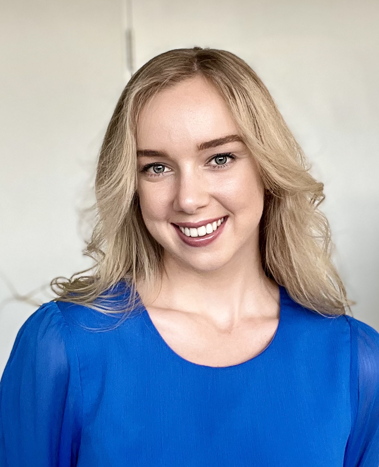 Headshot of blonde woman wearing blue