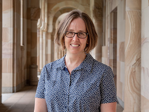 Assoicate Professor Heather Smyth standing in front of sandstone