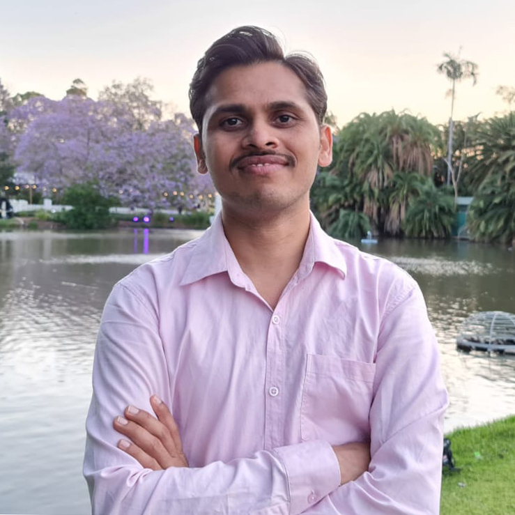 Dr Onkar Nath in front of UQ lakes with arms crossed