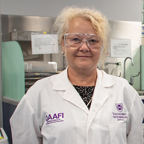 Headshot of Prof Ala Tabor in a lab setting wearing protective glasses and lab coat 