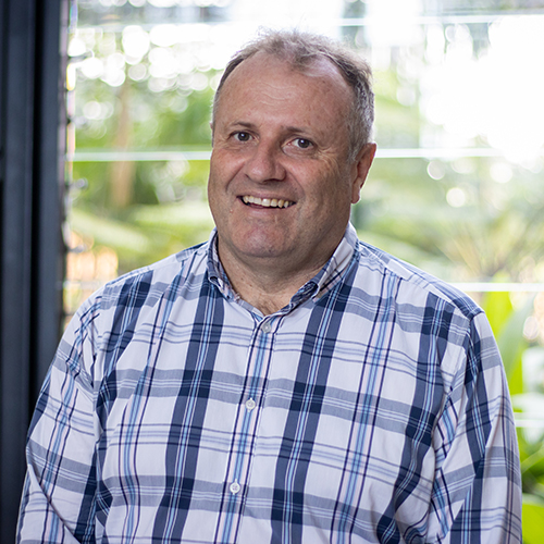 Headshot of Associate Professor Andrew Geering smiling at the camera