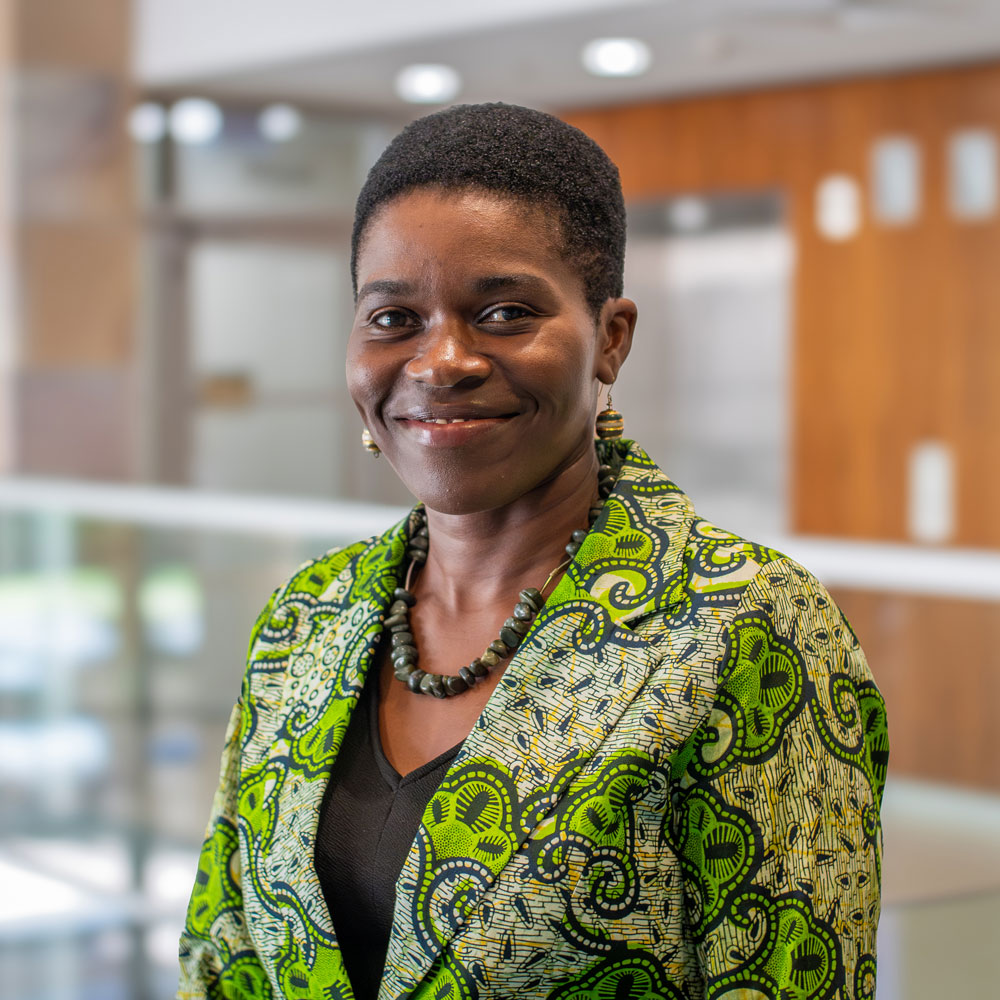 headshot of Associate Prof Sheila Ommeh with office building behind her 