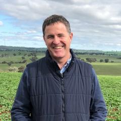 Headshot of Richard Heath with a field behind him