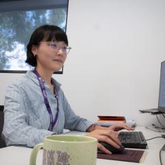 Dr Dongxue Zhao sitting at a desk in an office