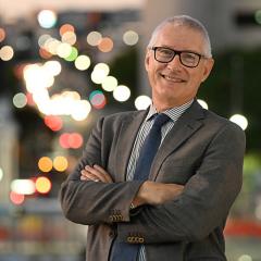 Headshot of Prof Matthew Morell with city lights blurred in the background