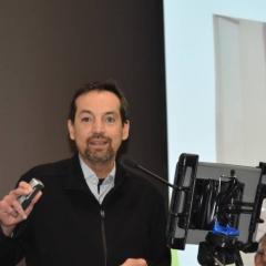 Professor Ben Hayes presenting at the conference, holding the device