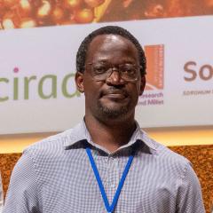 headshot of Daniel Otwani with signage behind him