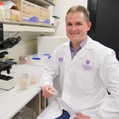 Dr Alistair McTaggart at a laboratory bench with specimans in jars