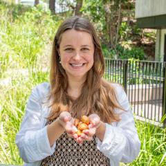 Dr Jaqueline Moura Nadolny holding bunya nuts in her cupped hands